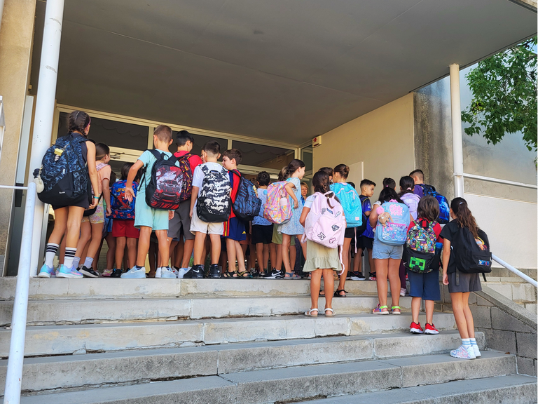 Alumnat de l’Escola Roc Blanc, a les escales d’entrada del centre, durant el primer dia del curs escolar.
